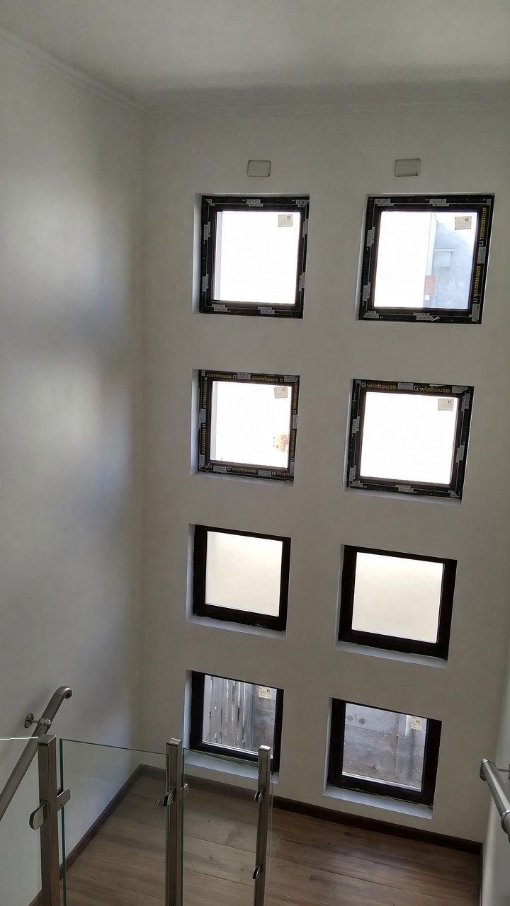 Caja de escalera con muro de ocho ventanas de vidrio esmerilado, pasamanos de acero inoxidable y baranda de vidrio